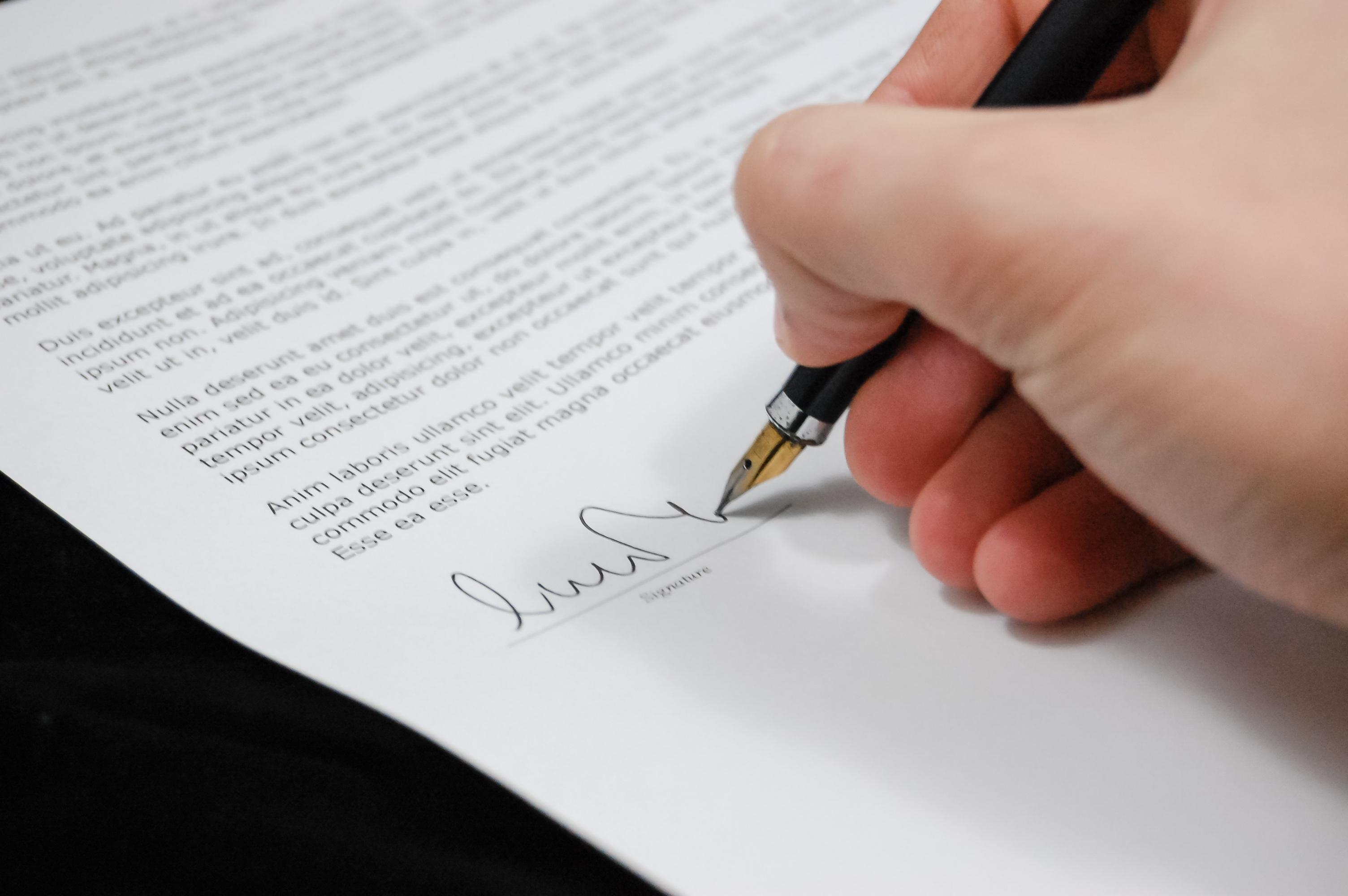 Person signing a piece of paper, used to indicate election certification,  CC0 from pexels.com