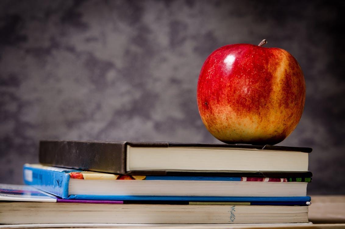 Books and an apple on a desk, to indicate education, CC0 from pexels.com